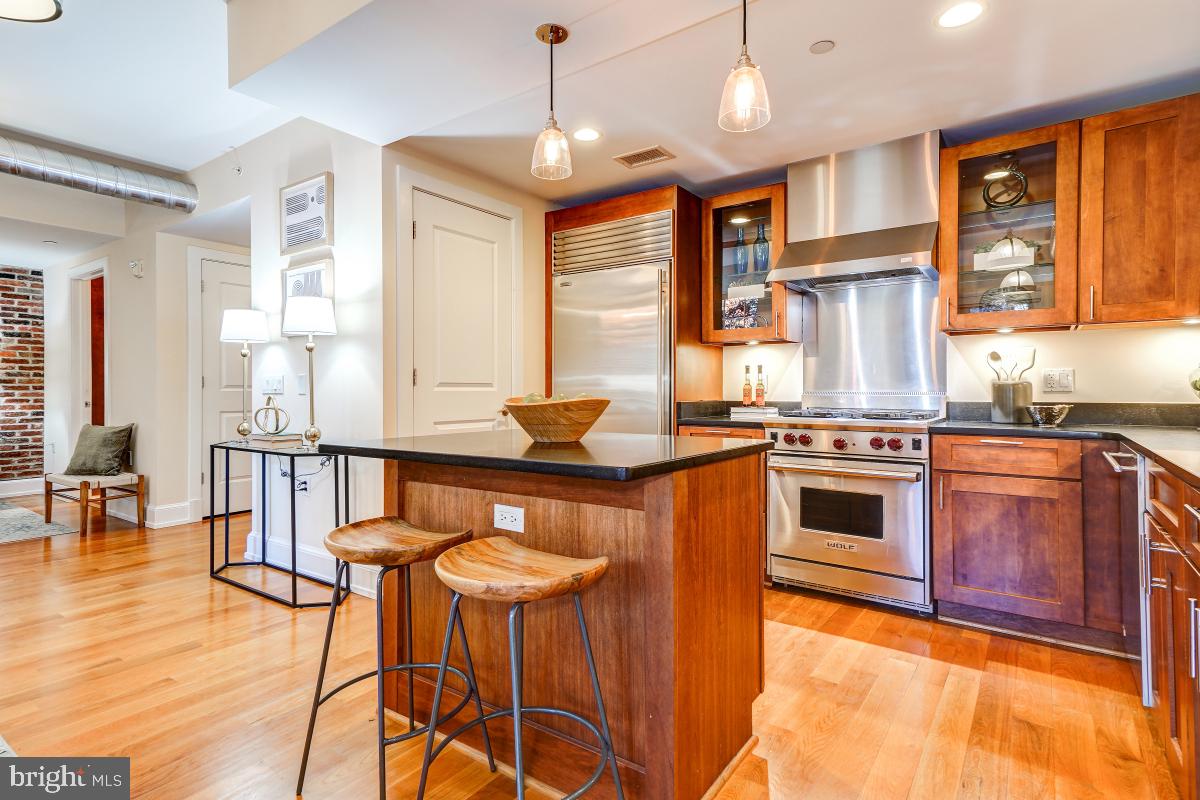 215 I Street Northeast, Unit 111 Washington, DC 20002 - Photo 14 of 34 a kitchen with stainless steel appliances granite countertop a stove a sink and a refrigerator