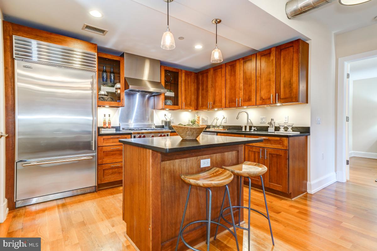 215 I Street Northeast, Unit 111 Washington, DC 20002 - Photo 15 of 34 a kitchen with stainless steel appliances granite countertop a refrigerator and a stove top oven