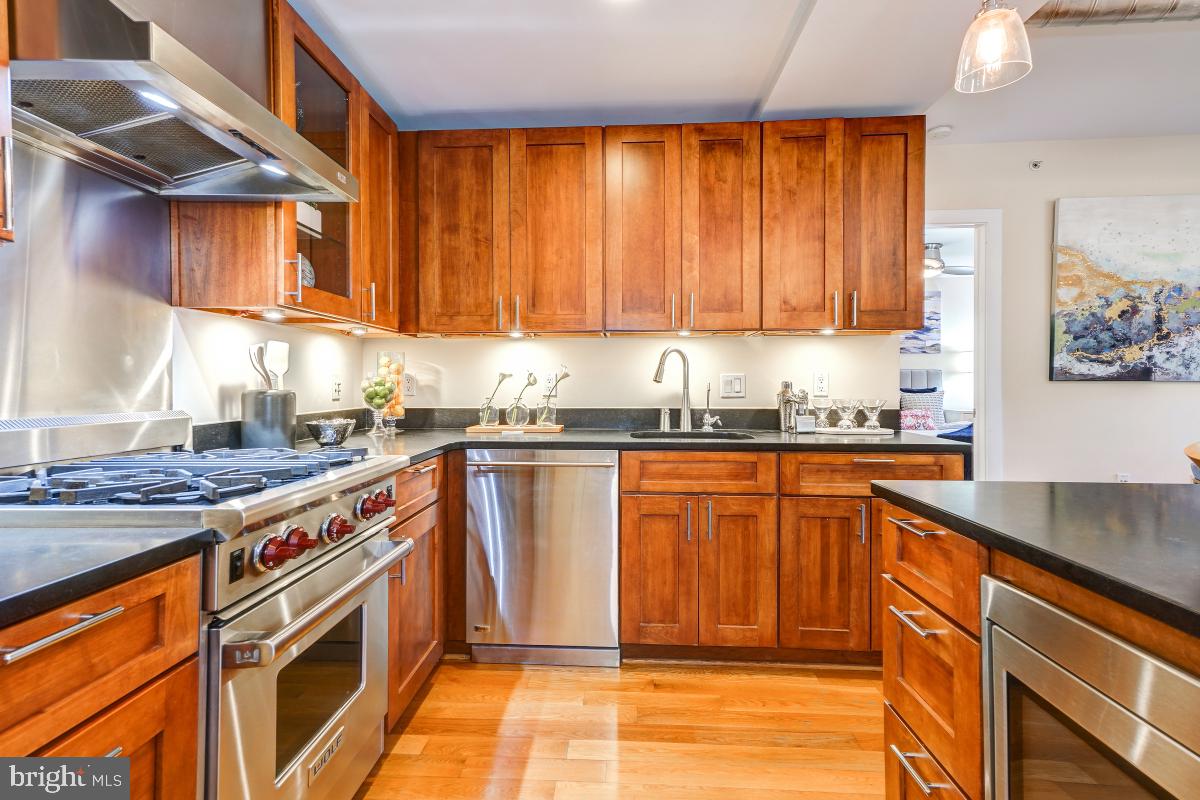 215 I Street Northeast, Unit 111 Washington, DC 20002 - Photo 16 of 34 a kitchen with stainless steel appliances granite countertop a stove a sink and a microwave