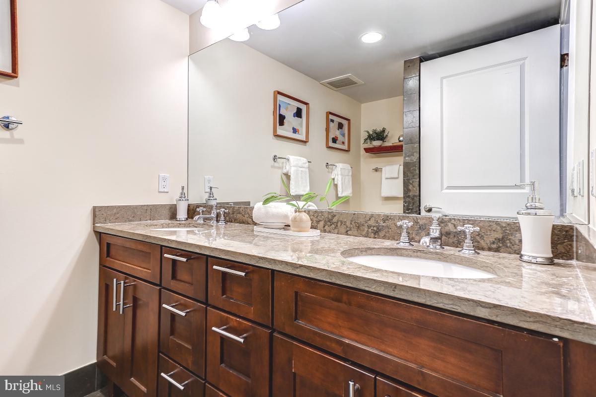 215 I Street Northeast, Unit 111 Washington, DC 20002 - Photo 21 of 34 a bathroom with a granite countertop sink a large mirror and a
