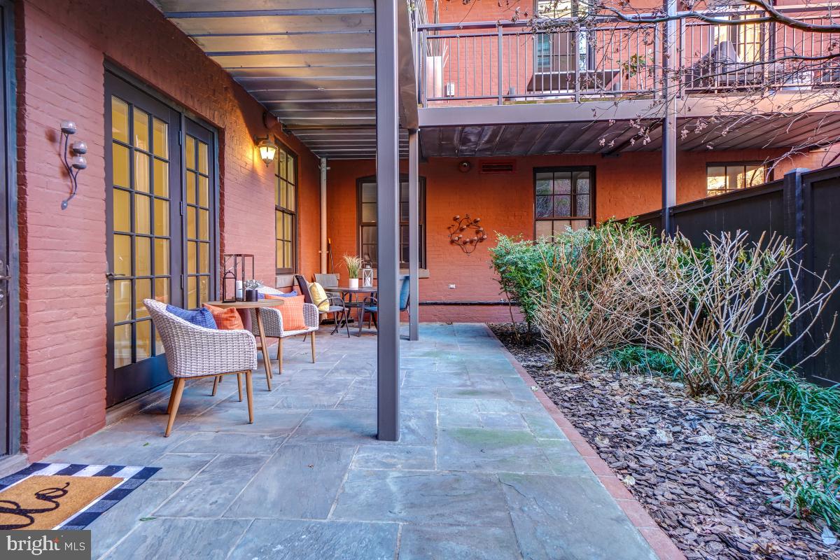215 I Street Northeast, Unit 111 Washington, DC 20002 - Photo 24 of 34 a view of a patio with a table and chairs and potted plants