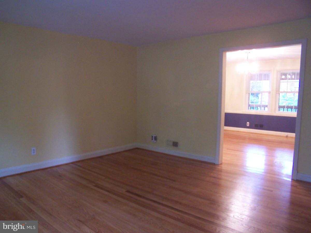 530 Academy Road Baltimore, MD 21228 - Photo 3 of 19 an empty room with wooden floor and windows