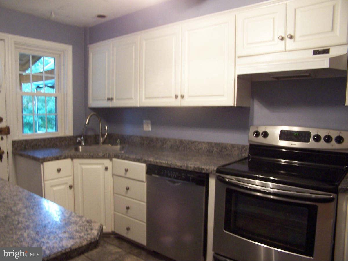 530 Academy Road Baltimore, MD 21228 - Photo 8 of 19 a kitchen with granite countertop white cabinets and appliances