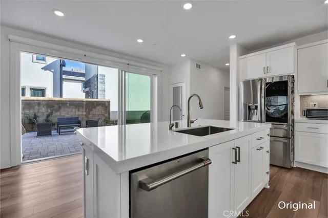 a kitchen with stainless steel appliances granite countertop a sink and a refrigerator