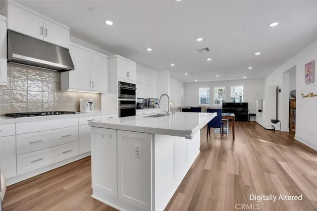 a kitchen with kitchen island a white counter top space a sink and cabinets