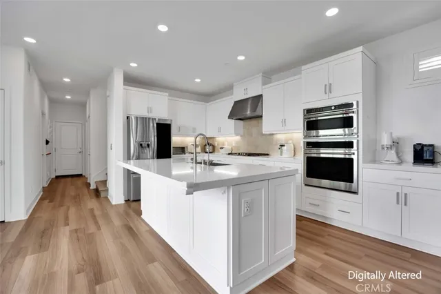 a kitchen with stainless steel appliances kitchen island granite countertop a stove and a sink