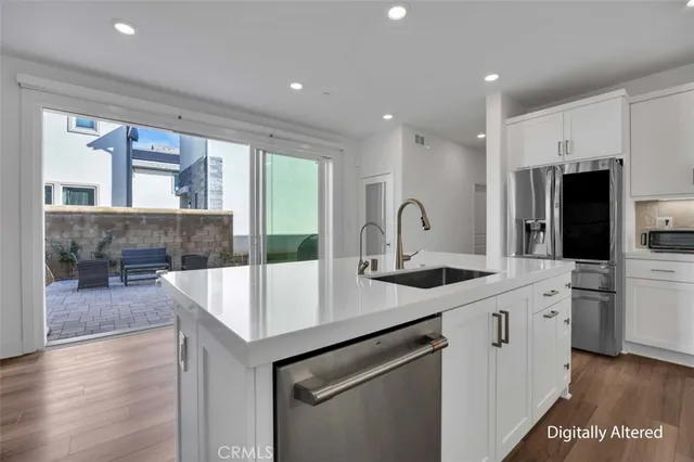 a kitchen with stainless steel appliances granite countertop a sink and a refrigerator