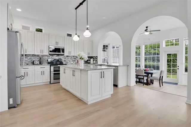 a kitchen with stainless steel appliances a stove a sink a center island and a refrigerator