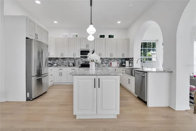 a kitchen with white cabinets and stainless steel appliances