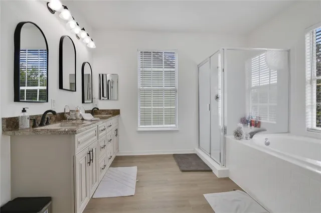 a bathroom with a tub sink and mirror