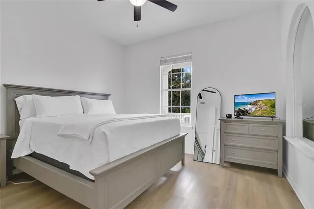 a white bed sitting in a bedroom next to a window