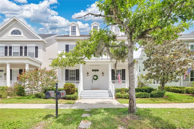 a front view of a house with a yard and trees
