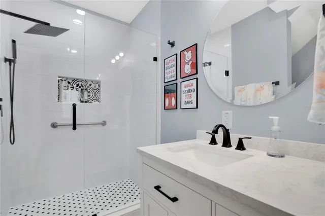 a bathroom with a sink a mirror and shower