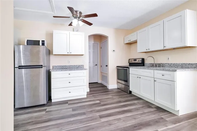 a kitchen with stainless steel appliances granite countertop a refrigerator and a stove top oven