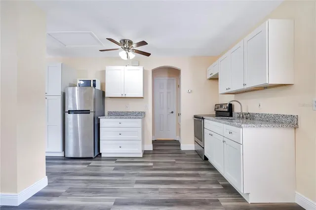 a kitchen with stainless steel appliances granite countertop a refrigerator and a stove top oven
