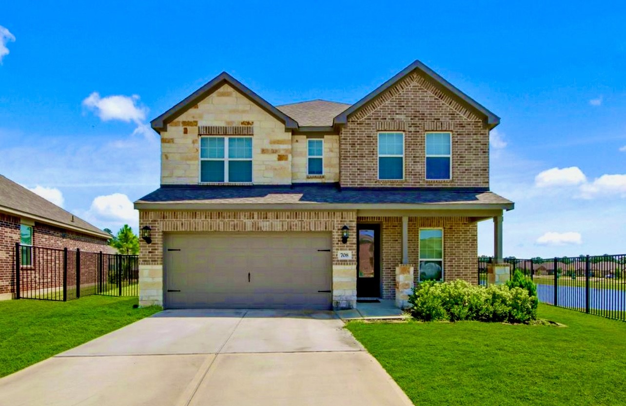 708 Fallen Hemlock Court Conroe, TX 77304 - Photo 1 of 15 a front view of a house with a yard and garage