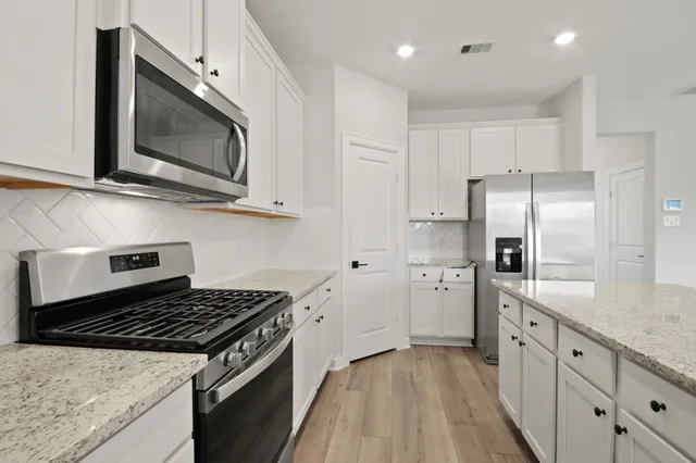 a kitchen with cabinets and steel stainless steel appliances