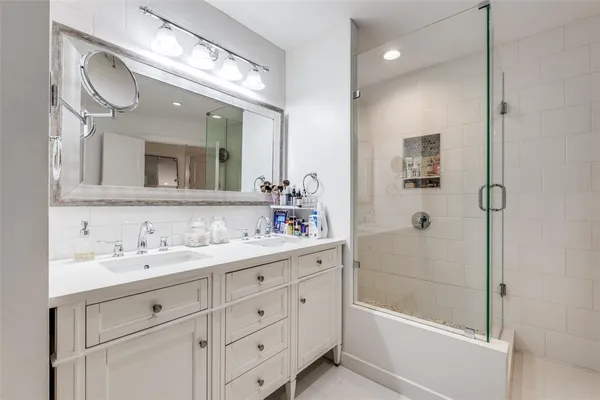 a bathroom with a sink a large mirror and shower