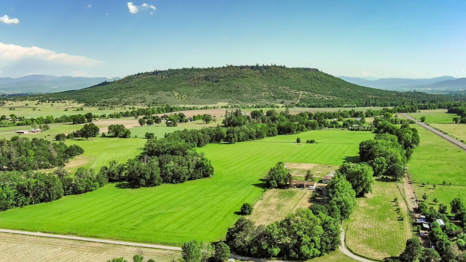 10710 Meadows Road White City, OR 97503 - Photo 2 of 46 an aerial view of green landscape with trees houses and mountain view