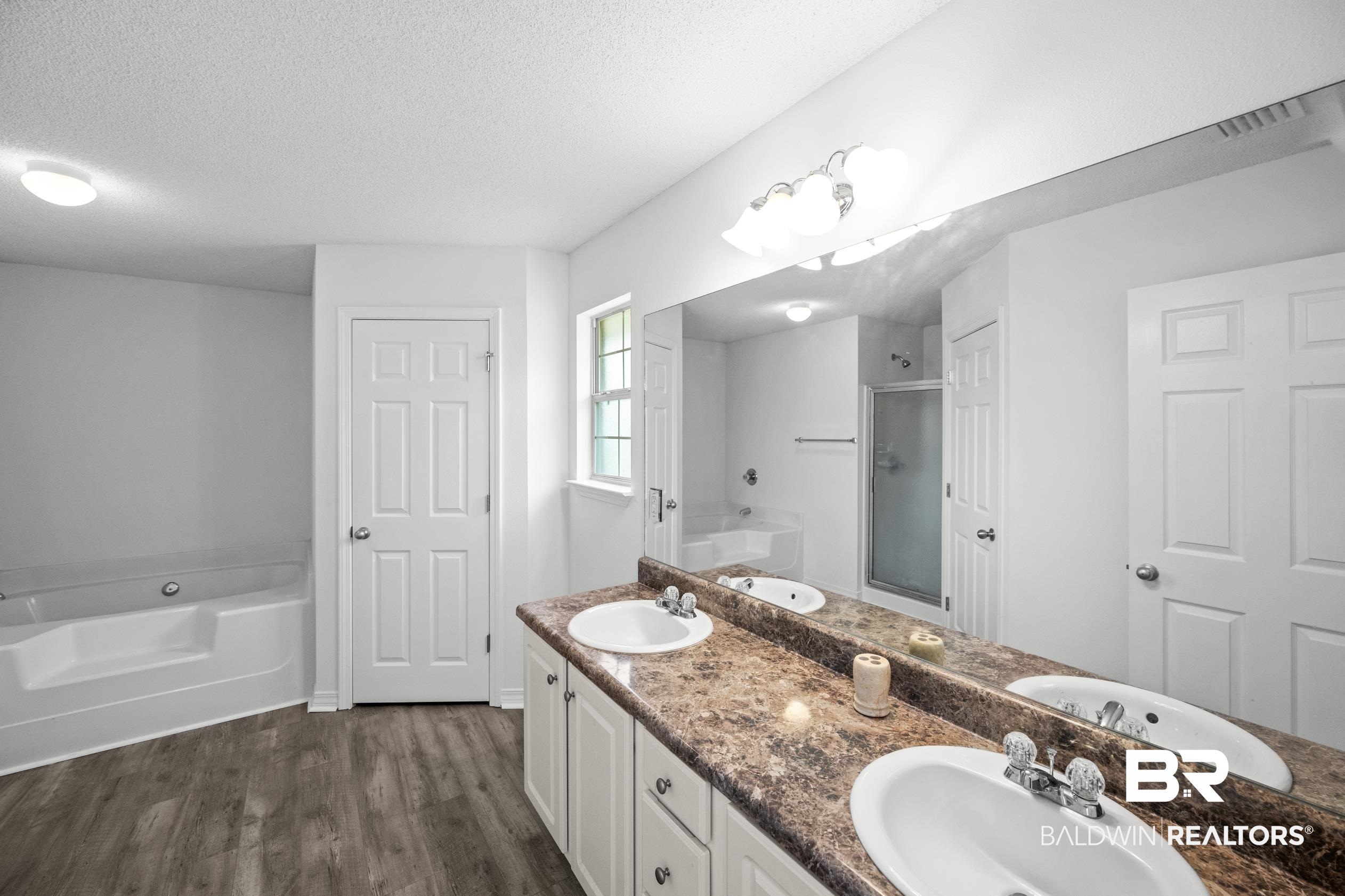 306 Monteith Oaks Drive Foley, AL 36535 - Photo 14 of 38 Full bathroom featuring a bath, a textured ceiling, a shower stall, double vanity, and dark wood-type flooring