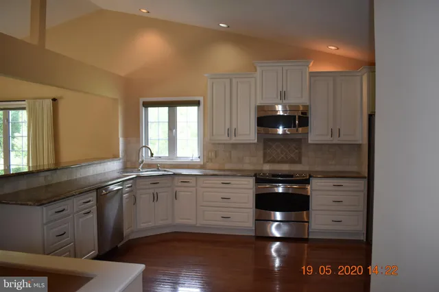 a kitchen with granite countertop a stove and cabinets
