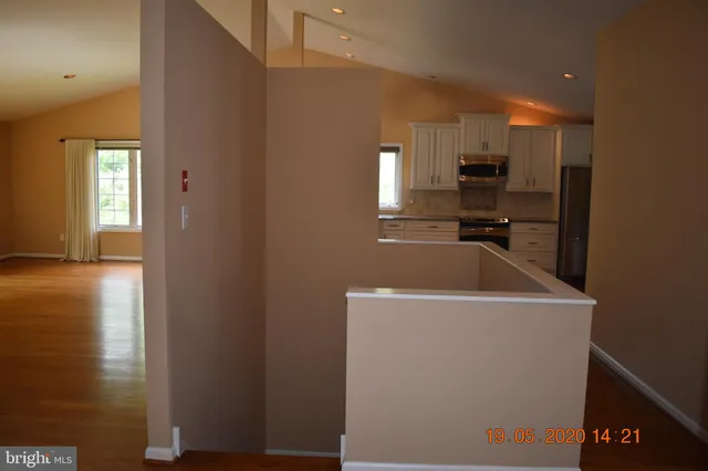 a view of a refrigerator a window and kitchen