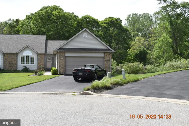 a view of a house with a patio and a yard