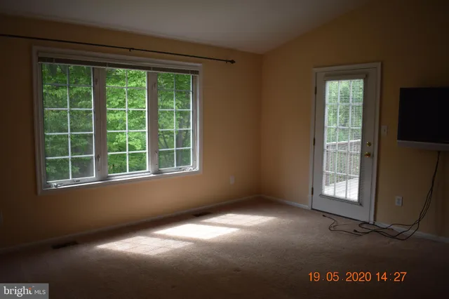 a view of empty room with wooden floor and fireplace