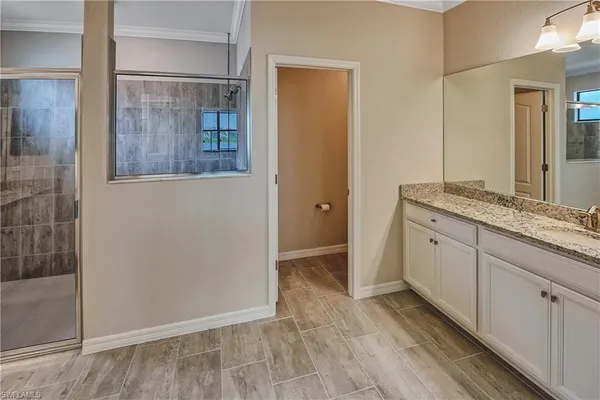 a bathroom with a granite countertop sink a mirror and a shower
