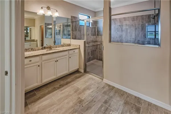 a bathroom with a double vanity sink mirror and shower