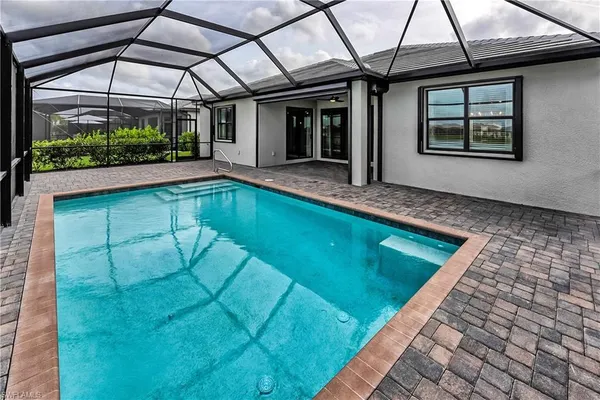 a view of a backyard patio with swimming pool and outdoor seating