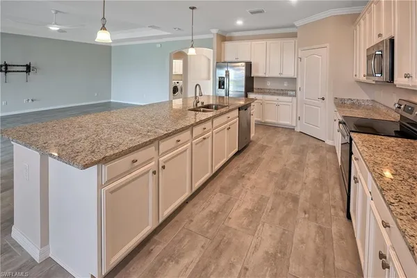 a large kitchen with kitchen island a sink stainless steel appliances and cabinets