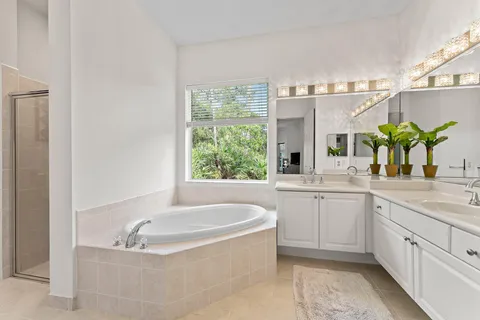 a bathroom with a granite countertop sink a bathtub and window