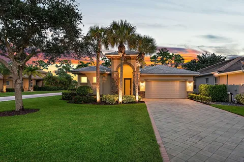 a front view of a house with a yard and trees