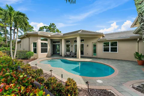 a view of a house with a swimming pool and sitting area