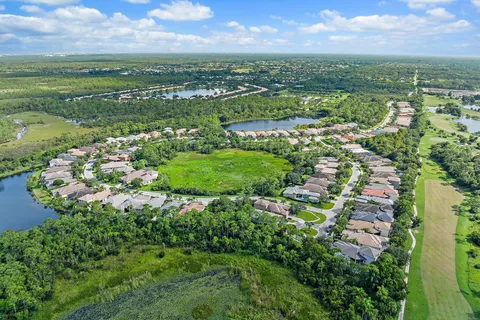 an aerial view of residential houses with outdoor space and trees