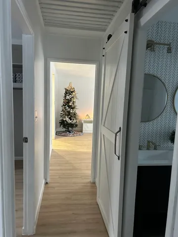 a view of a hallway with wooden floor and staircase