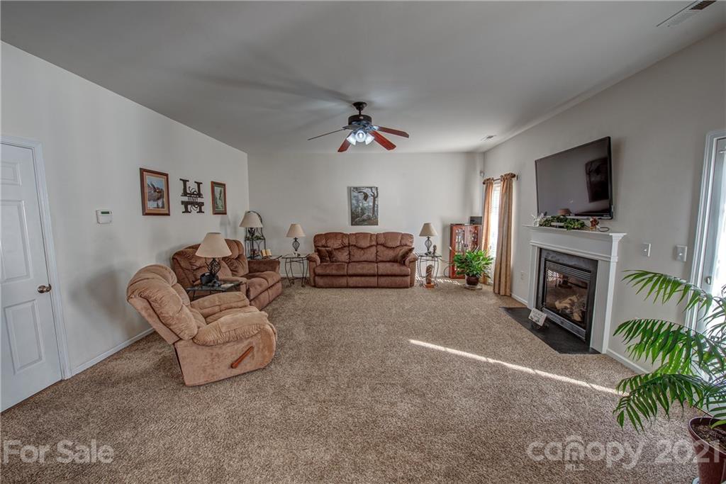 5202 Sunriver Road Gastonia, NC 28054 - Photo 14 of 29 a living room with furniture a fireplace and a flat screen tv