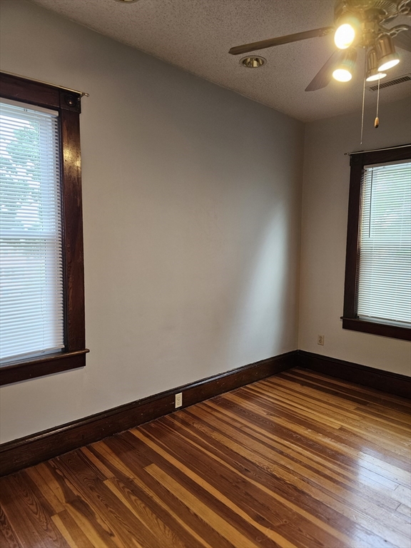 404 Stevens Street, Unit 2 Lowell, MA 01851 - Photo 12 of 12 a view of an empty room with wooden floor and a window