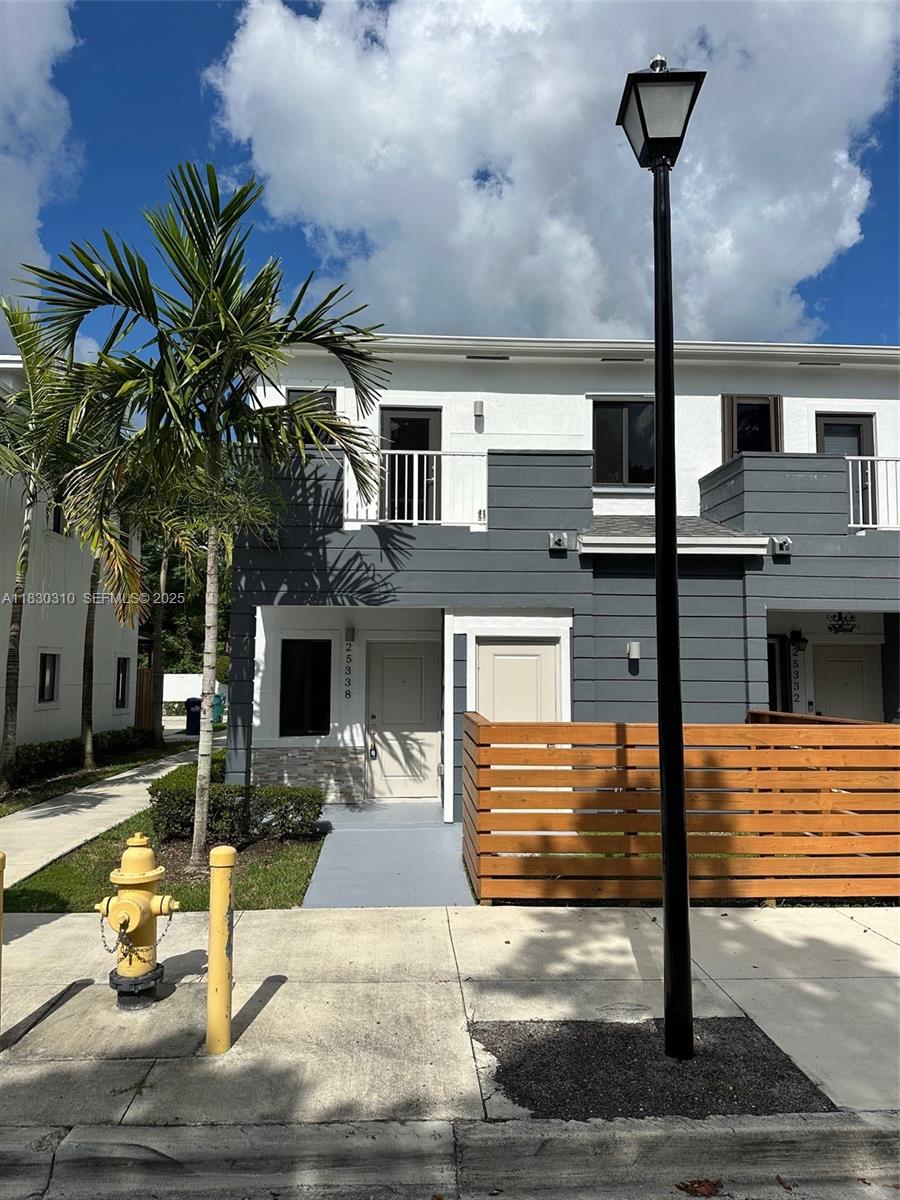 25338 Southwest 135th Avenue, Unit 107 Homestead, FL 33032 - Photo 1 of 26 a front view of a house with garage