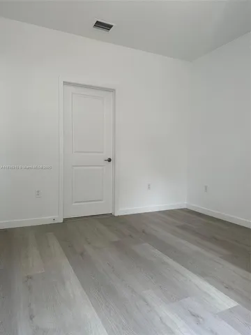 an empty room with wooden floor and closet