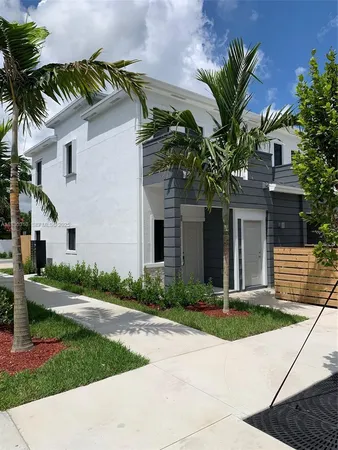 a front view of a house with a yard and potted plants