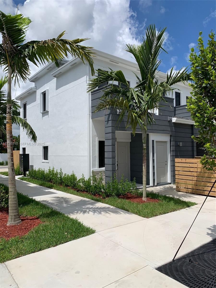 25338 Southwest 135th Avenue, Unit 107 Homestead, FL 33032 - Photo 2 of 26 a front view of a house with a yard and potted plants