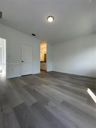 a view of empty room with window and wooden floor