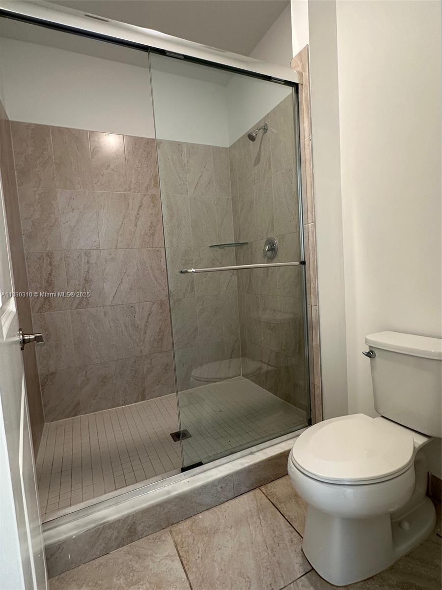 25338 Southwest 135th Avenue, Unit 107 Homestead, FL 33032 - Photo 25 of 26 a bathroom with a shower and a toilet