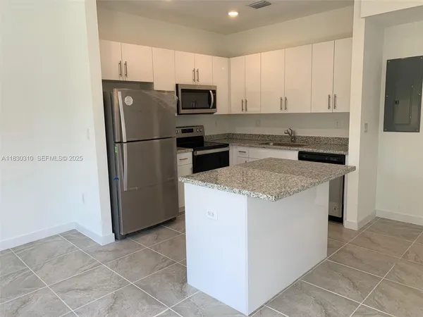 a kitchen with a stove a microwave and a refrigerator