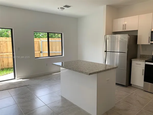 a kitchen with stainless steel appliances granite countertop a refrigerator and a stove