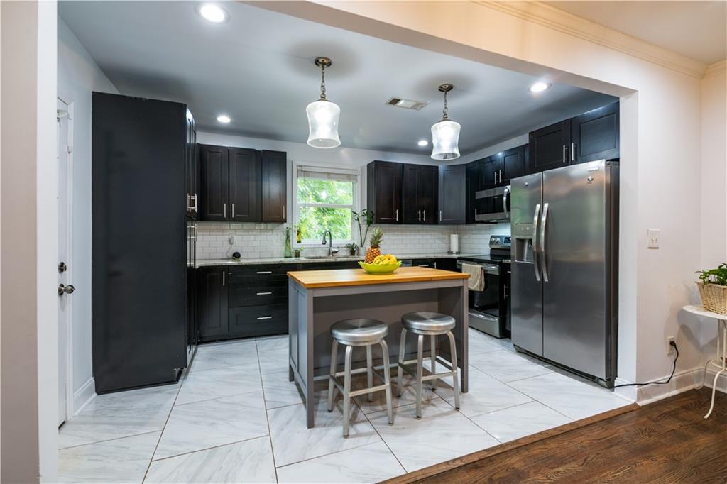 1760 Rogers Avenue Southwest Atlanta, GA 30310 - Photo 18 of 57 a kitchen with stainless steel appliances kitchen island granite countertop a refrigerator and a sink