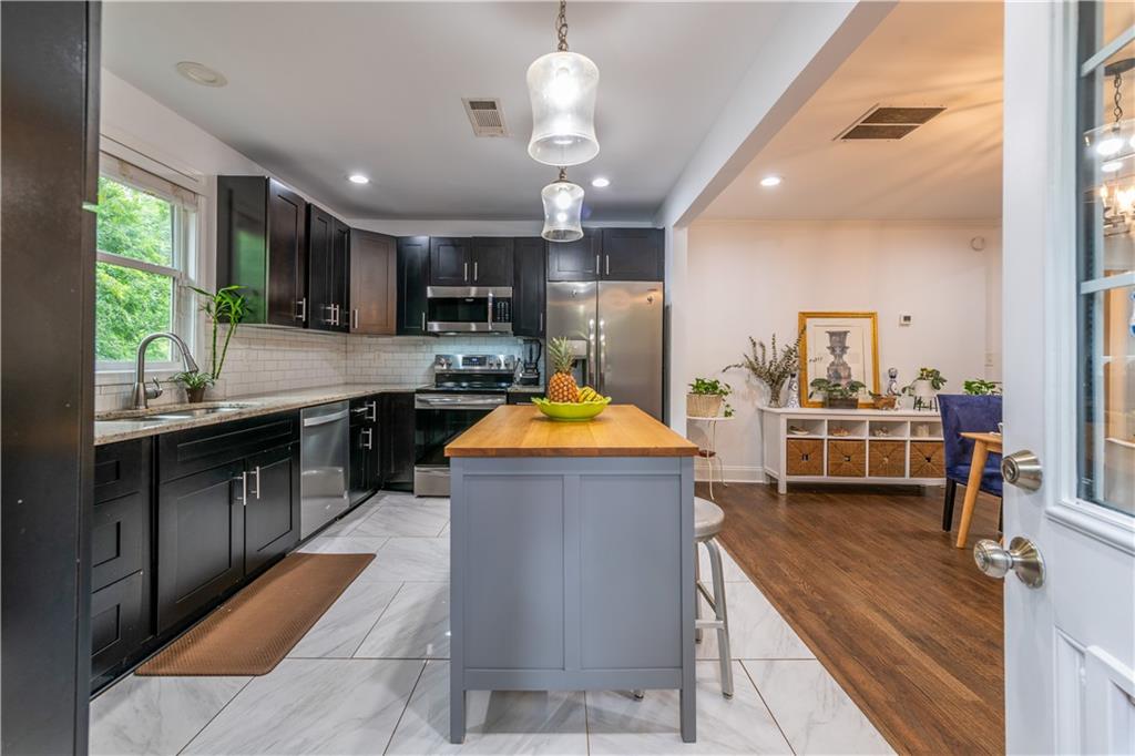 1760 Rogers Avenue Southwest Atlanta, GA 30310 - Photo 21 of 57 a kitchen with stainless steel appliances granite countertop counter space a sink and a refrigerator