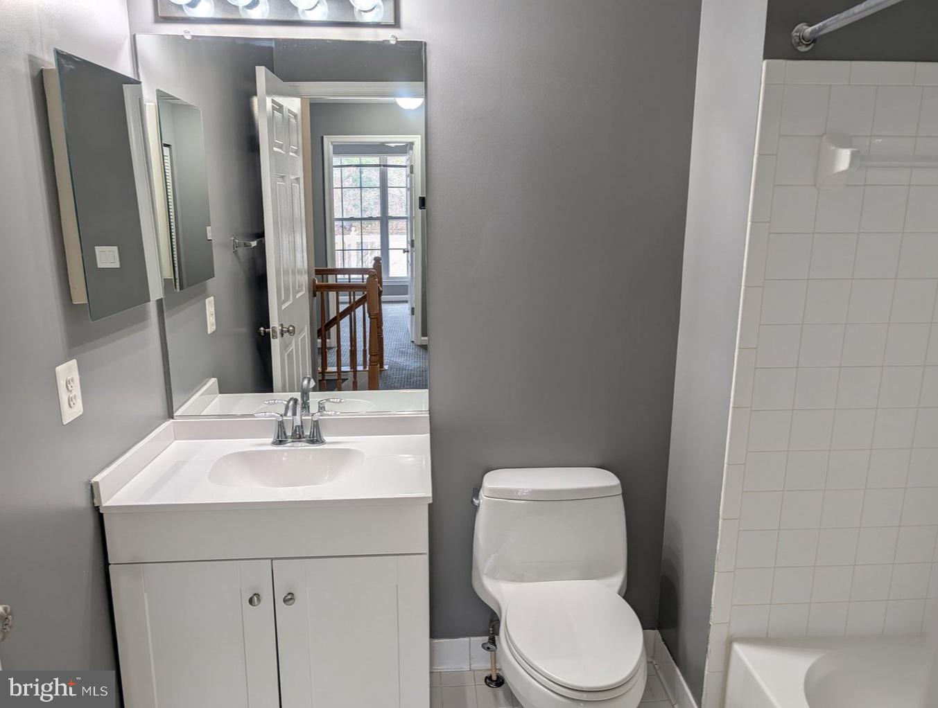 1891 Crescent Park Drive, Unit 110A Reston, VA 20190 - Photo 24 of 41 a bathroom with a toilet sink vanity and mirror